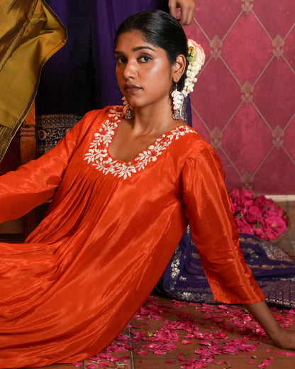 Radiate vibrant elegance with this striking orange ethnic set